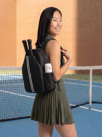 Woman with Rally Cross Body Backpack in Black at outdoor pickleball court