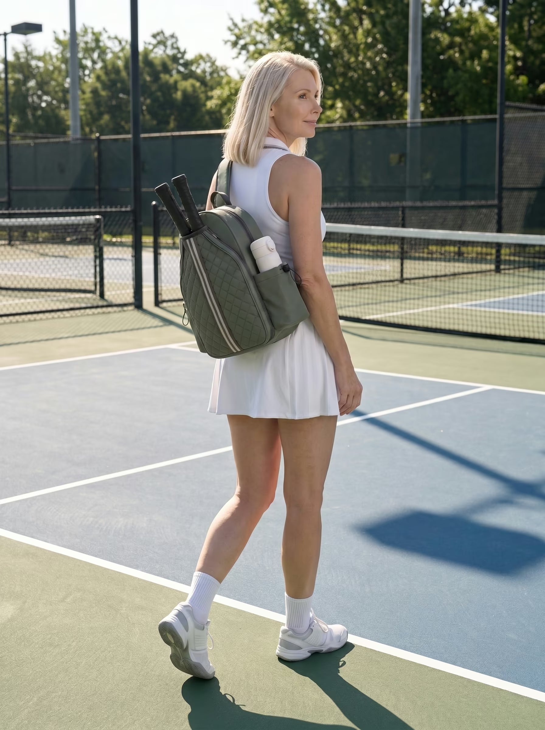 Woman with Rally Cross Body Backpack in Green at outdoor pickleball court